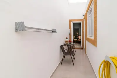 a hallway with white walls and a chair and a table at Manolis and Anna's House in Malona Village