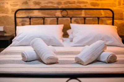 a bed with two rolled up towels on it at Manolis and Anna's House in Malona Village