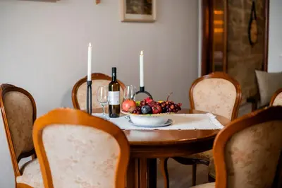 a table with two bottles of wine and a bowl of fruit at Manolis and Anna's House in Malona Village