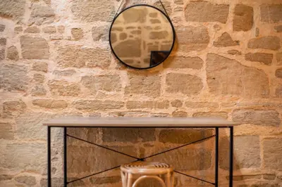 a table with a mirror on a brick wall at Manolis and Anna's House in Malona Village