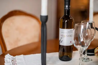 a bottle of wine sitting on a table with two glasses at Manolis and Anna's House in Malona Village