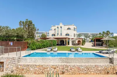 a villa with a swimming pool in front of a building at Paradise Beach I in Kiotari