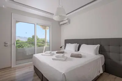 a bedroom with a large white bed with a large window at Paradise Beach I in Kiotari