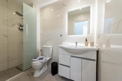 a white bathroom with a toilet and a sink at Hella apartment in Rhodes Town