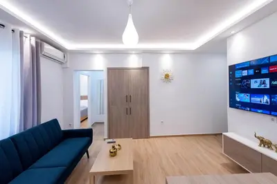 a living room with a blue couch and a table at Hella apartment in Rhodes Town