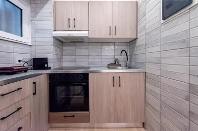 a kitchen with wooden cabinets and a sink at Hella apartment in Rhodes Town