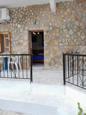 a gate in front of a building with a stone wall at 