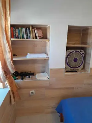 a room with a fan on a wooden floor at 