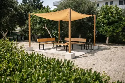 a gazebo with two benches in a park at ANGELOS STUDIOS 1-2 in Faliraki Rhodes-Ground Floor in Faliraki