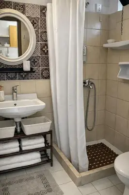 a bathroom with a shower curtain and a sink at ANGELOS STUDIOS 1-2 in Faliraki Rhodes-Ground Floor in Faliraki