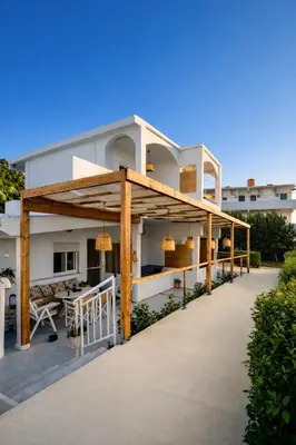a patio of a house with awnings and tables at ANGELOS STUDIOS 1-2 in Faliraki Rhodes-Ground Floor in Faliraki