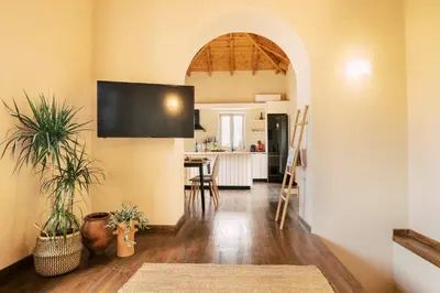 a kitchen and living room with a flat screen tv at Rizes Traditional House in Phanaes
