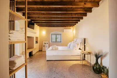 a bedroom with a white bed and a loft at Rizes Traditional House in Phanaes