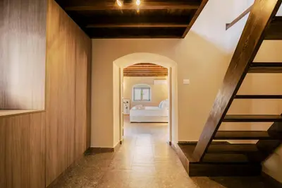 a hallway with a staircase and a room with a bed at Rizes Traditional House in Phanaes