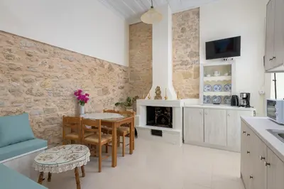 a kitchen and dining room with a table and a fireplace at Rhodes Heaven Jasmine in Malona Village