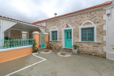 a stone house with blue doors and a patio at Rhodes Heaven Jasmine in Malona Village