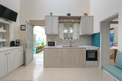 a kitchen with wooden cabinets and a sink and a microwave at Rhodes Heaven Jasmine in Malona Village