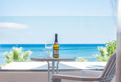 a bottle of wine sitting on a table on the beach at Lido Star in Faliraki