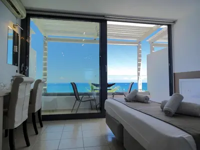 a bedroom with a bed and a view of the ocean at Lido Star in Faliraki