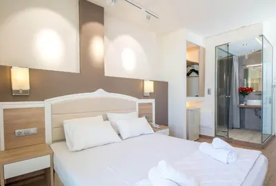 a bedroom with a large white bed with white pillows at Lido Star in Faliraki