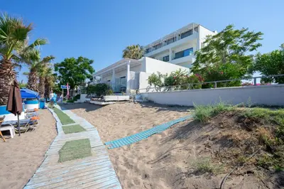 a sandy beach in front of a building at Lido Star in Faliraki