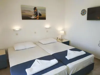 a bedroom with a bed and a painting on the wall at Hotel Narkissos in Archangelos