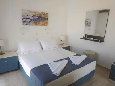 a bedroom with a bed with two towels on it at Hotel Narkissos in Archangelos