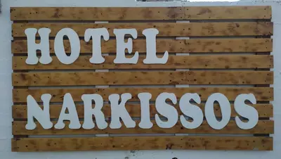 a sign for a hotel varanasi on a wall at Hotel Narkissos in Archangelos