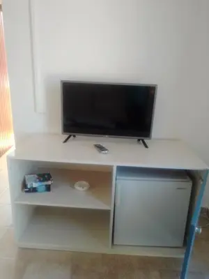 a white stand with a tv on top of it at Hotel Narkissos in Archangelos