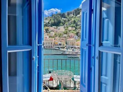 an open window with a view of a harbor at Nikolakis, Seafront- Harbor view in Symi