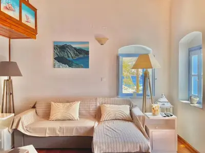 a living room with a couch and a window at Nikolakis, Seafront- Harbor view in Symi