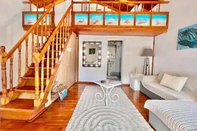 a living room with a staircase and a couch at Nikolakis, Seafront- Harbor view in Symi