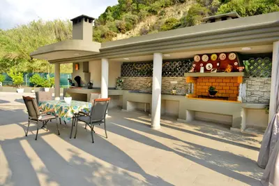 a patio with a table and chairs and a bar at Villa with private pool Zambakas in Kalithies