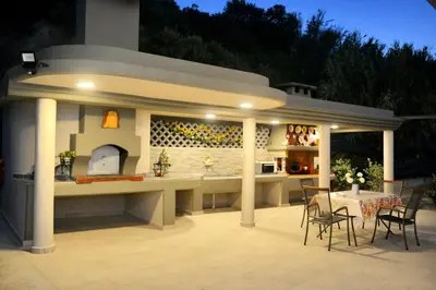 a patio with a table and chairs and a kitchen at Villa with private pool Zambakas in Kalithies