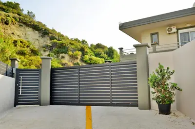 a gate in front of a house with a hill at Villa with private pool Zambakas in Kalithies
