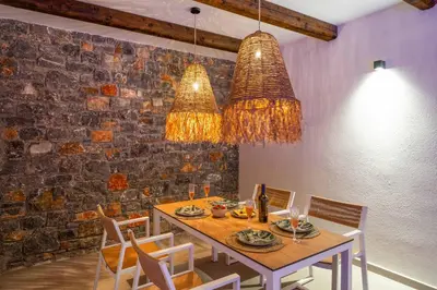 a dining room with a table and chandeliers at Villa Margarita Gennadi in Gennadi