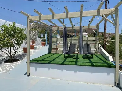 a pergola with two chairs on a lawn at Sylvia's Beach House in Stegna in Archangelos