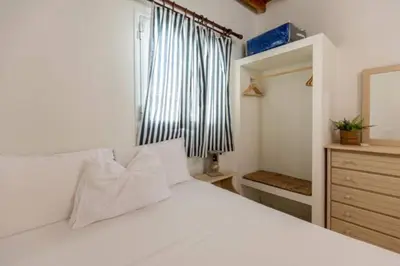 a bedroom with a white bed and a window at Sylvia's Beach House in Stegna in Archangelos