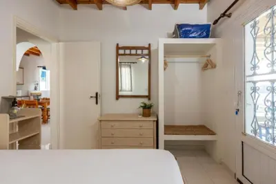 a bedroom with a bed and a sink and a mirror at Sylvia's Beach House in Stegna in Archangelos