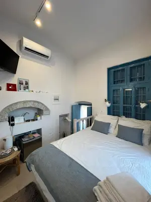 a bedroom with a large bed with a blue headboard at Little Gem Symi Boutique Studio in Symi