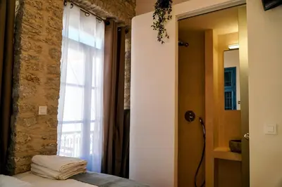 a bedroom with a window and a bed with towels at Little Gem Symi Boutique Studio in Symi