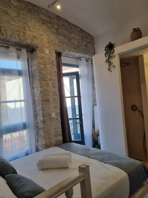 a bedroom with a large bed with a brick wall at Little Gem Symi Boutique Studio in Symi