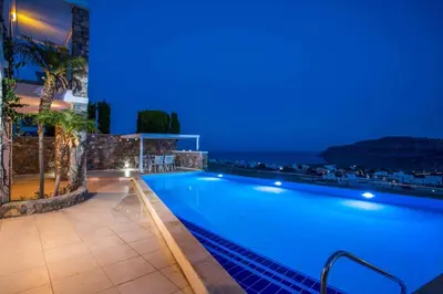 a swimming pool at night with blue lights at Villa Karma Lindos in Líndos