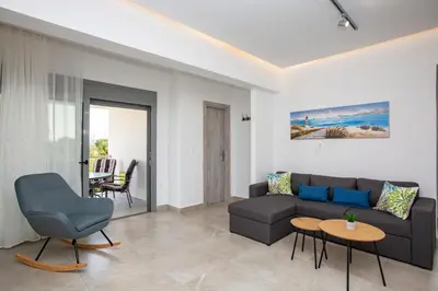 a living room with a couch and a table at SoL Apt Faliraki in Faliraki