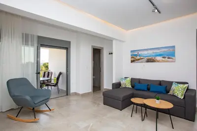 a living room with a couch and a table at SoL Apt Faliraki in Faliraki