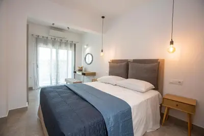 a bedroom with a large bed with a blue blanket at SoL Apt Faliraki in Faliraki