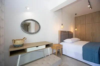 a bedroom with a bed and a mirror and a table at SoL Apt Faliraki in Faliraki