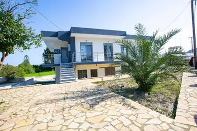 a house with a palm tree in front of it at SoL Apt Faliraki in Faliraki