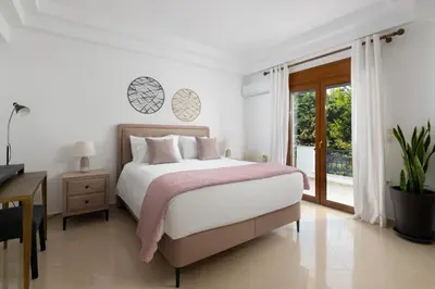 a bedroom with a bed and a desk and a window at Villa Annatoli in Koskinou