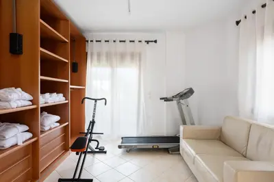 a living room with a couch and a treadmill at Villa Annatoli in Koskinou